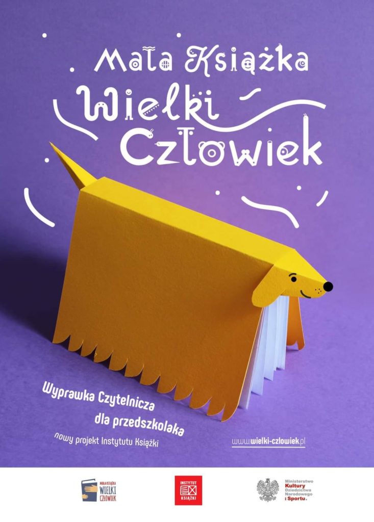 Na fioletowym tle żółta książka postawiona grzbietem do góry z doklejonym ogonem i głową psa. Powyżej duży napis "Mała książka - wielki człowiek". W prawym dolnym rogu napis: "Wyprawka czytelnicza dla przedszkolaka. Nowy projekt Instytutu Książki", obok adres strony internetowej www.wielki-czlowiek.pl. Poniżej na białym pasku logo akcji Mała książka - Wielki Człowiek, Instytutu Książki i Ministerstwa Kultury, Dziedzictwa Narodowego i Sportu.