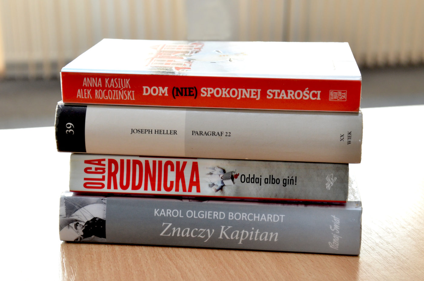 Książki polecane w Poczekalni literackiej: od góry: "Dom (nie) spokojnej starości" Anna Kasiuk, Alek Rogoziński, "Paragraf 22" Joseph Heller, "Oddaj albo gin!" Olga Rudnicka, "Znaczy Kapitan" Karol Olgierd Borchardt.