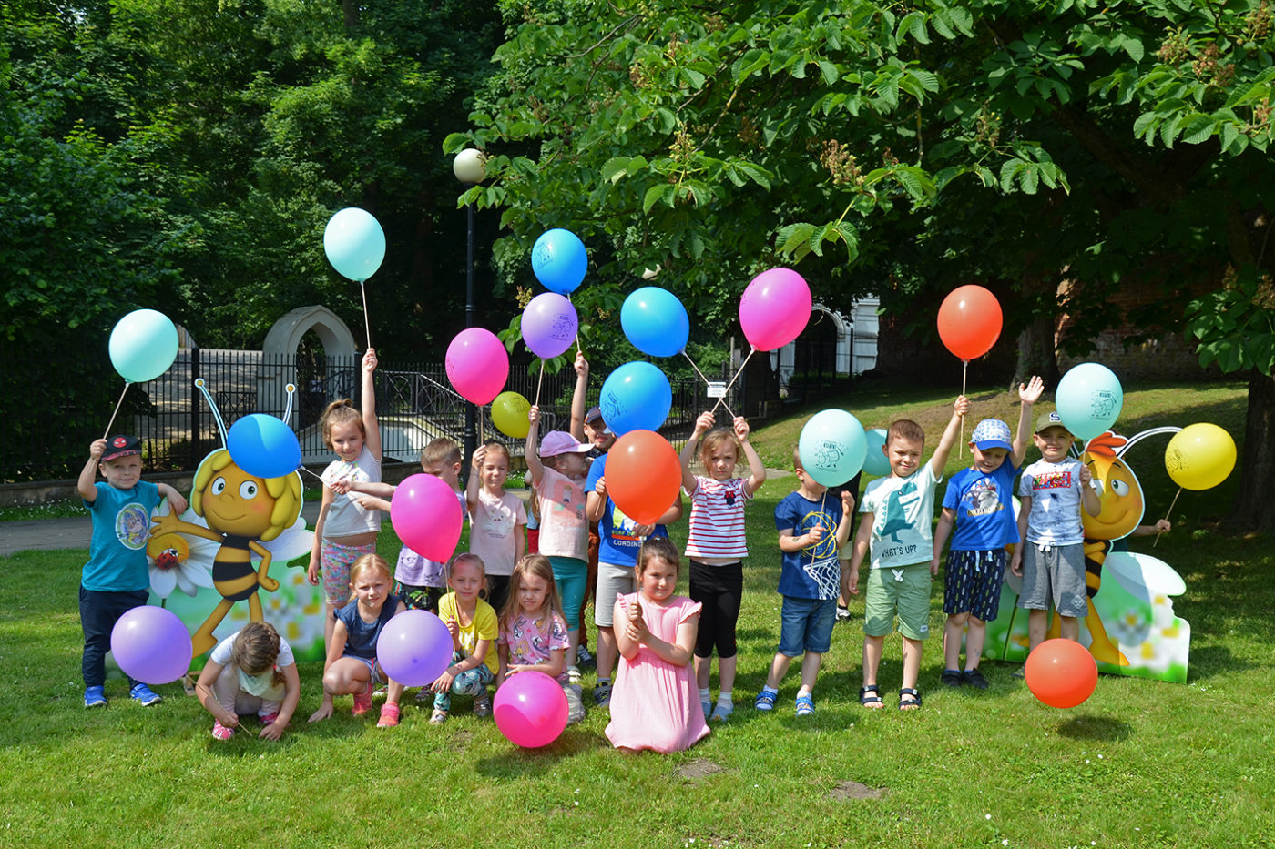 Na zdjęci: grupa dzieci pozuje do zdjęcia trzymając wysoko w górze kolorowe balony.