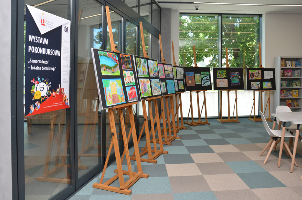 Wystawa pokonkursowa "Samorządność - lokalna demokracja". Na zdjęciu: plansze ze zwycięskimi pracami plastycznymi ustawione na sztalugach.